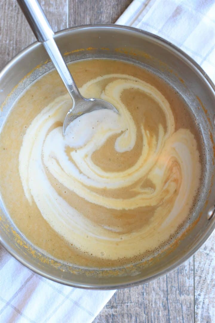 Stirring coconut milk into soup