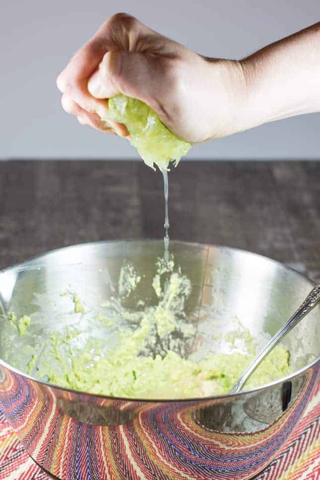 Squeezing lime juice into the dip in the mixing bowl