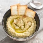 overhead of hummus in bowl with crackers in it