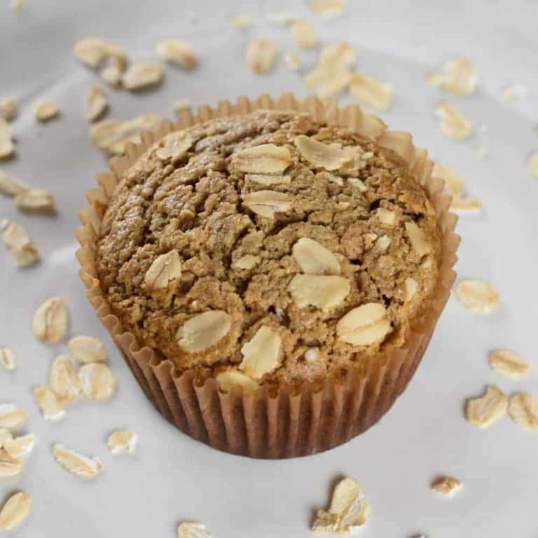 one muffin on a plate with raw oats around it