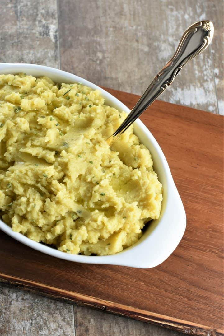 mashed potatoes in white serving dish with spoon in it