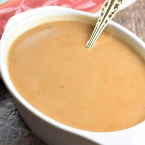 gravy in white serving dish with spoon in it