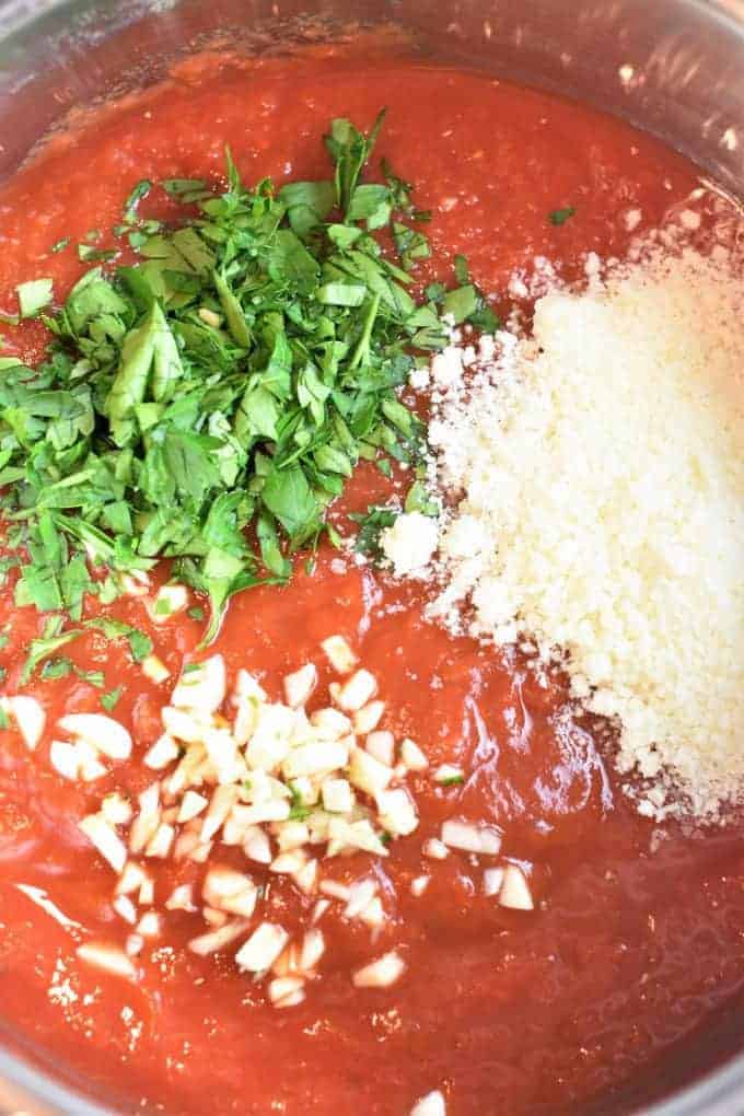 Pot of crushed tomatoes, parsley, cheese and garlic