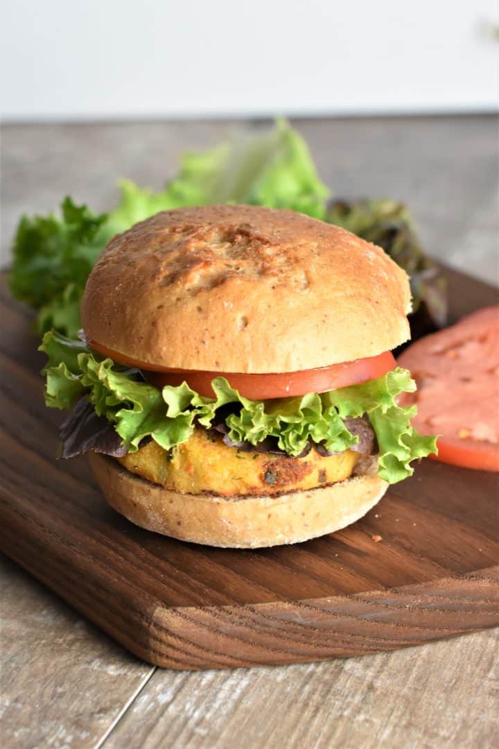 Veggie burger sitting on a wood cutting board