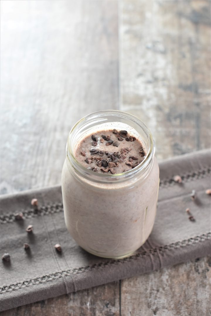 smoothie in mason jar topped with cacao nibs