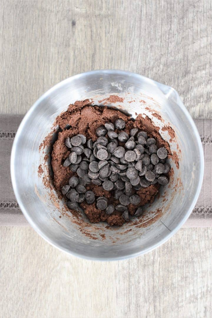 Chocolate chips added to ingredients in a mixing bowl