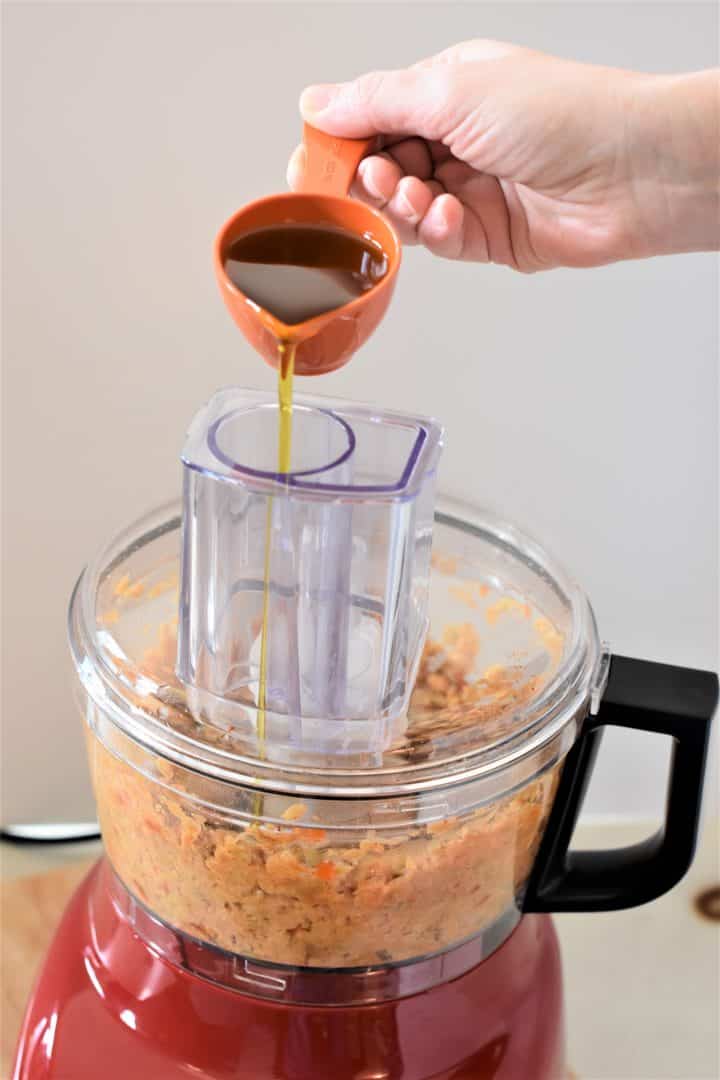 Pouring olive oil into a running food processor