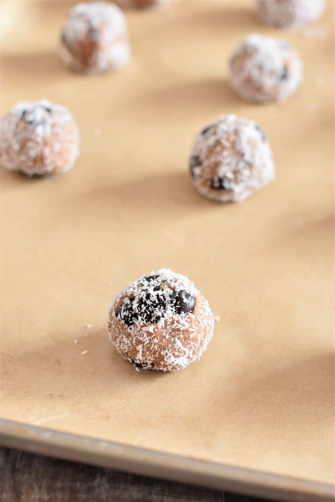 cookie bites on parchment on a baking sheet with one in front in focus