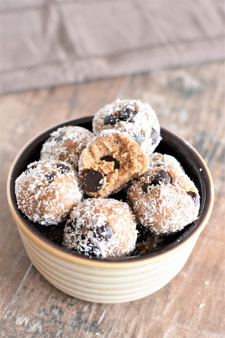 Almond Butter Cookie Dough Bites in a small bowl with bite taken out of the top one