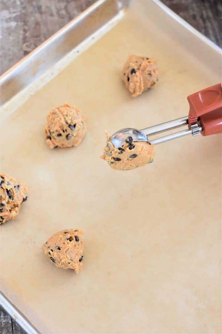Scooping peanut butter balls onto a baking sheet