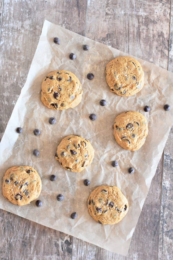 overhead of cookies on parchment with chocolate chips around