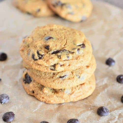 stack of 3 cookies on parchment with two more blurred out in the background