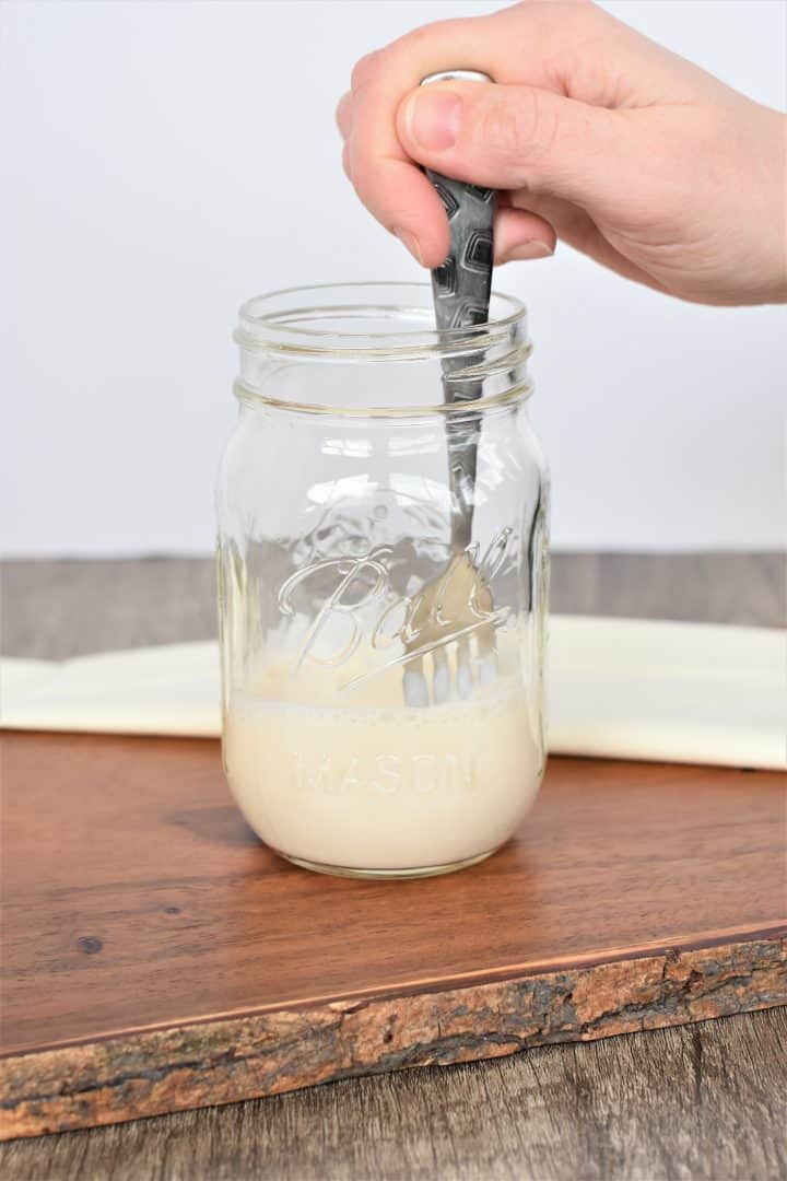 stirring vinegar into soy milk with a fork

