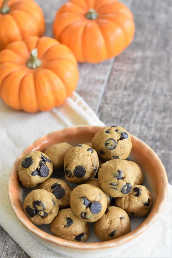 slight overhead of pumpkin balls in a bowl with mini pumpkins in the background