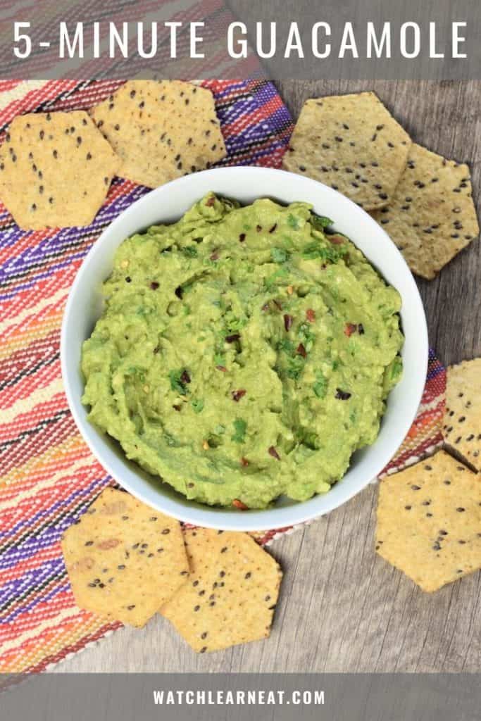 pin showing overhead of guacamole in a white bowl with tortilla chips around it