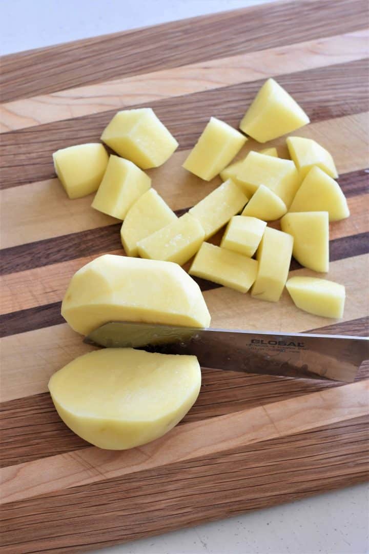 chopping potatoes with a knife on a cutting board