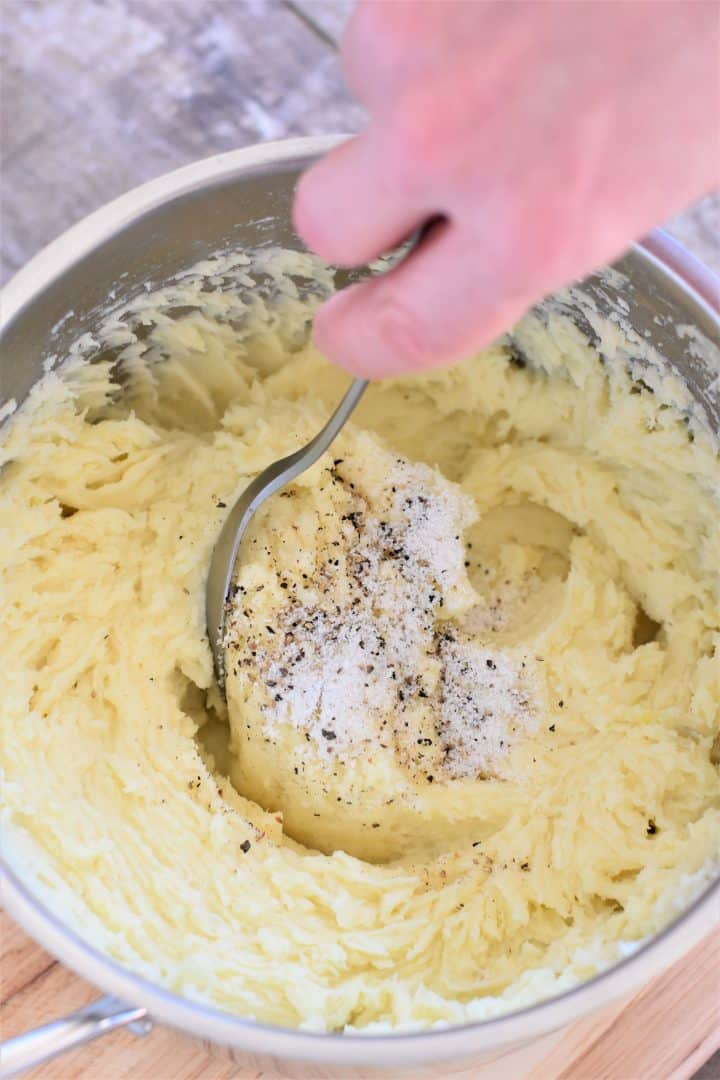 stirring salt and pepper into the mashed potatoes