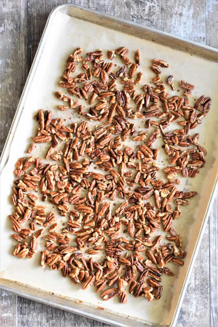 pecans laid out on baking sheet with parchment paper