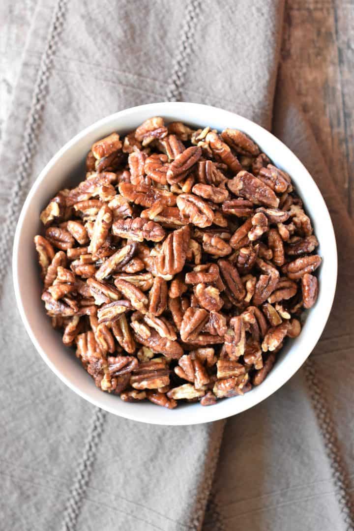 overhead shot of roasted pecans in a white bowl