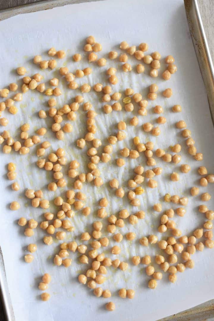 Chickpeas spread out evenly on the baking sheet