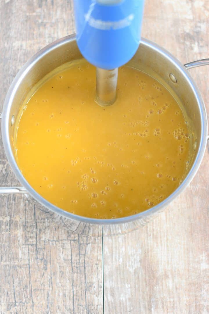 using immersion blender to puree the soup