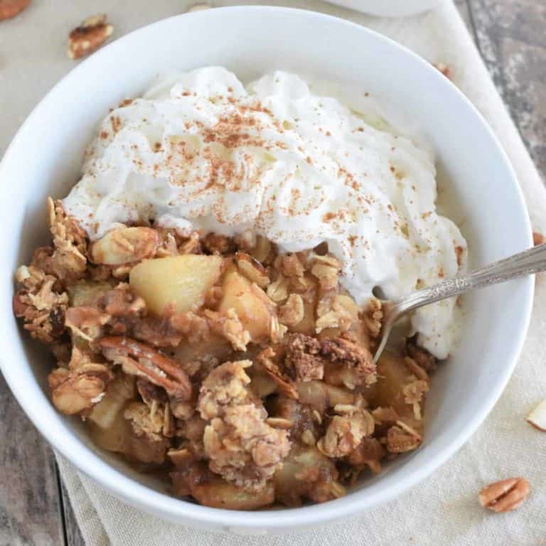 Overhead of pear crisps with spoon in white bowl