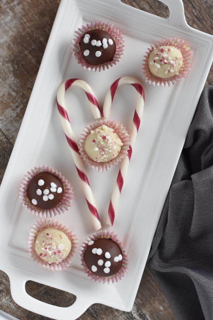 truffles on a white serving platter with two candy canes forming a heart around one of them