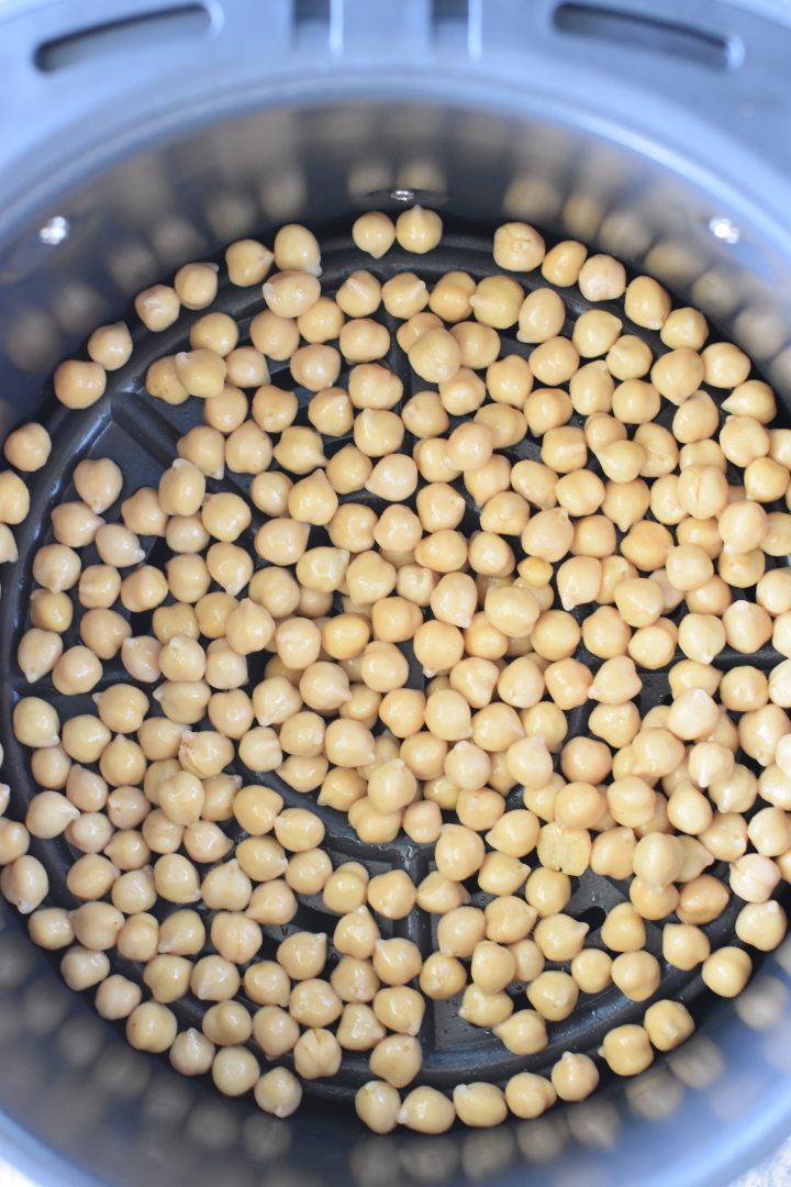 Chickpeas added to air fryer after being mixed with olive oil