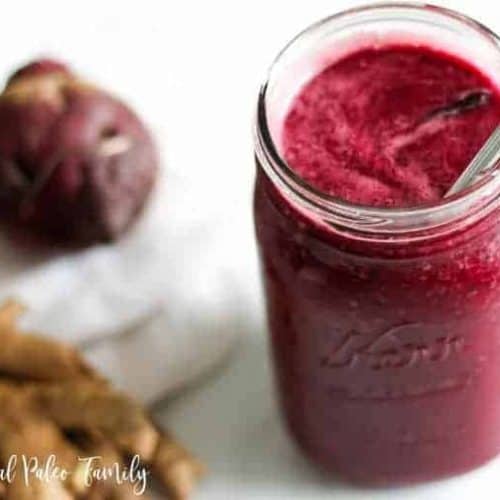 beet smoothie in a mason jar with a straw.