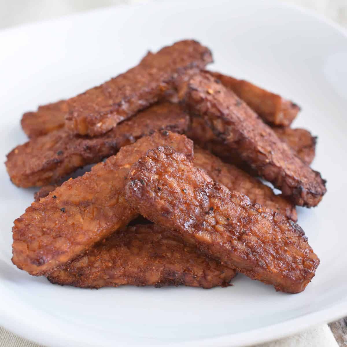 front view of tempeh bacon on white plate