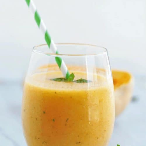 butternut squash smoothie in a glass with a straw.