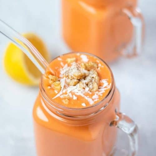 carrot cake smoothie in mason jar with a straw.
