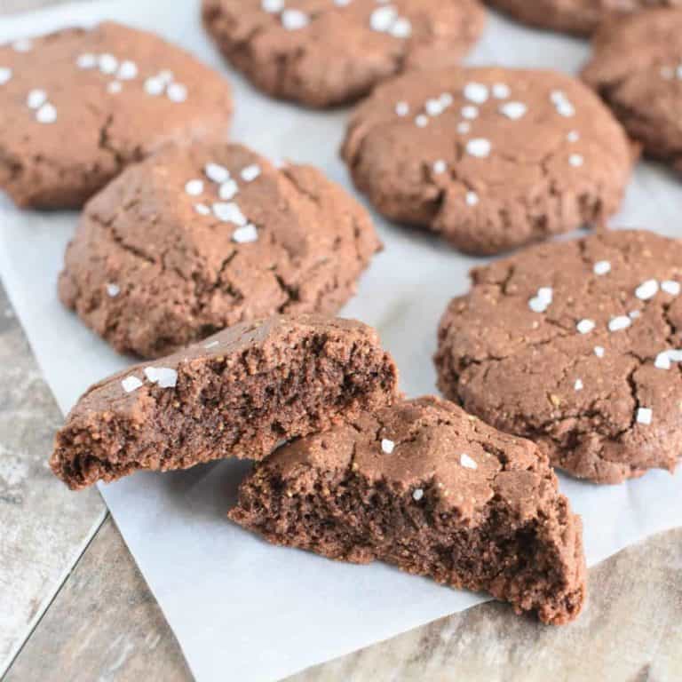 chocolate cookies on parchment with front one broken in half to see the inside
