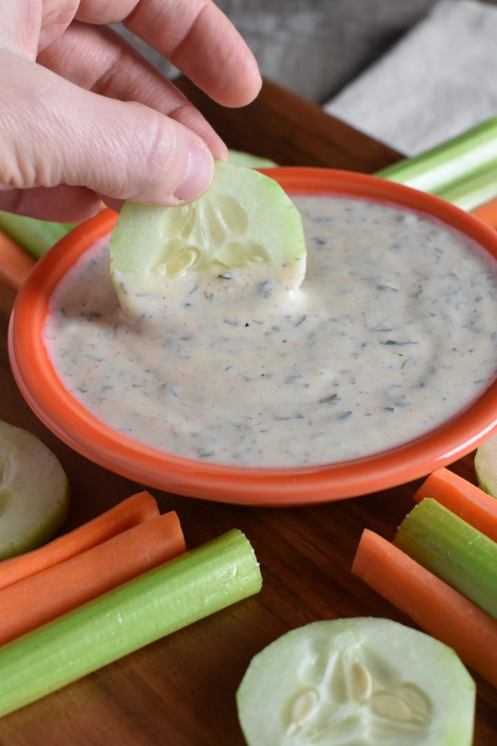 Dipping a cucumber slice into the ranch