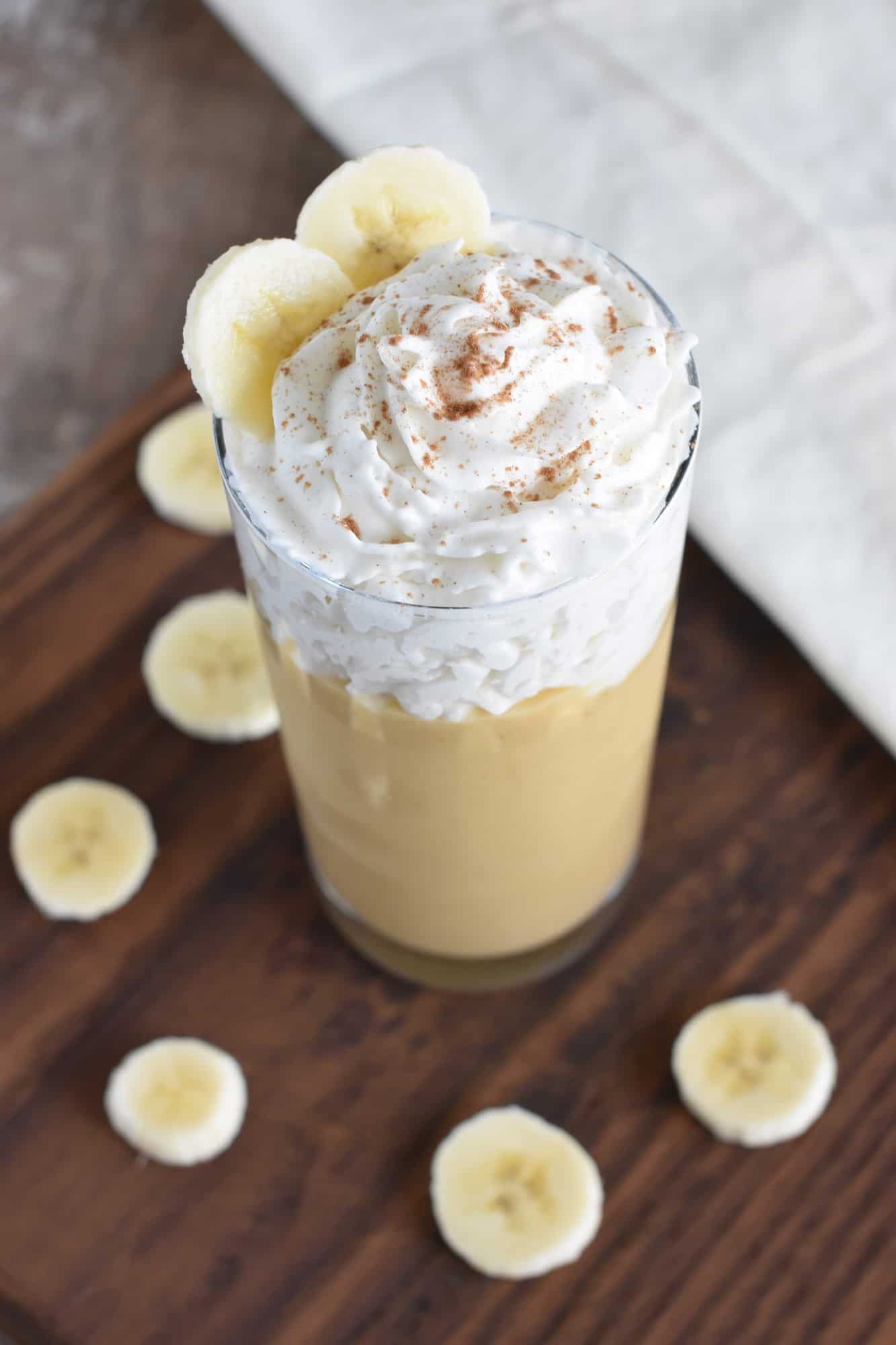smoothie topped with dairy-free whipped topping, cinnamon and banana slices