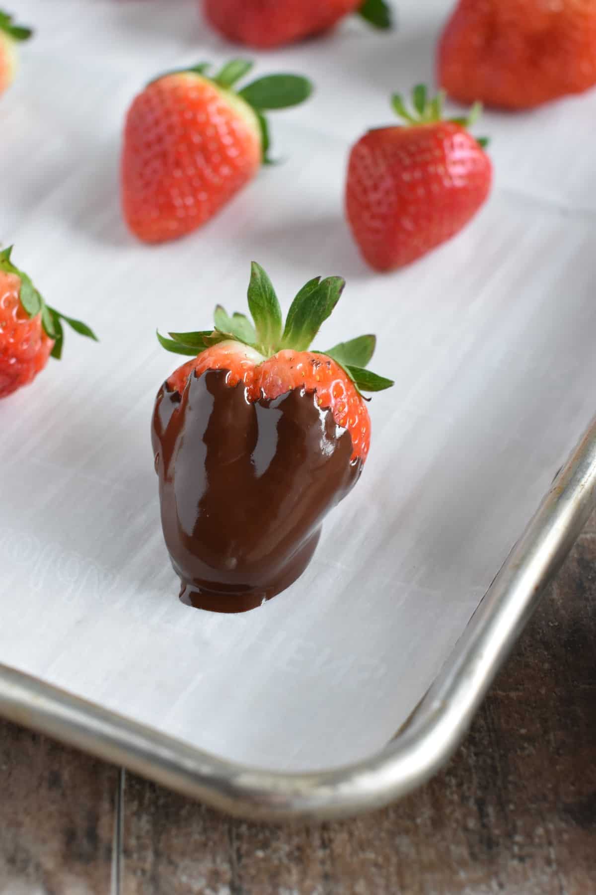 chocolate dipped strawberry placed back on the parchment-lined baking sheet