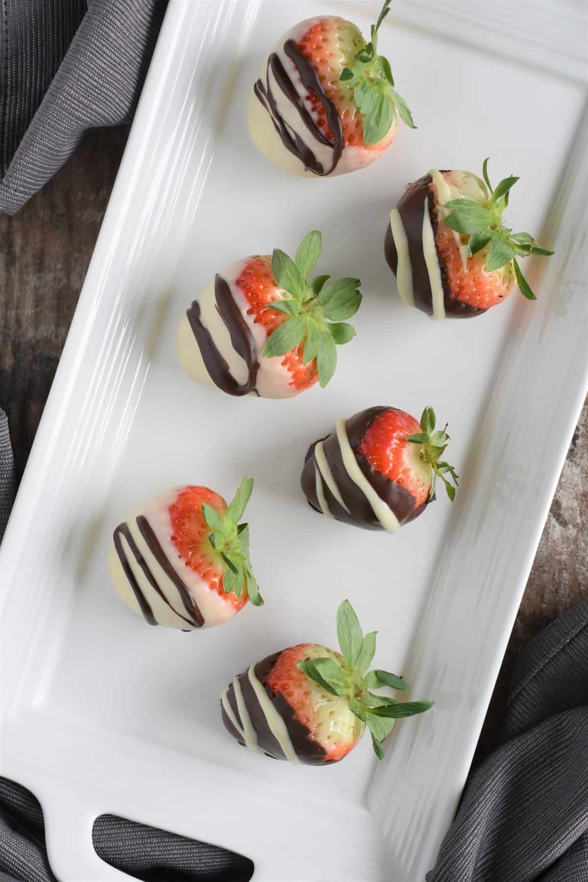 overhead of vegan chocolate covered strawberries on white serving platter
