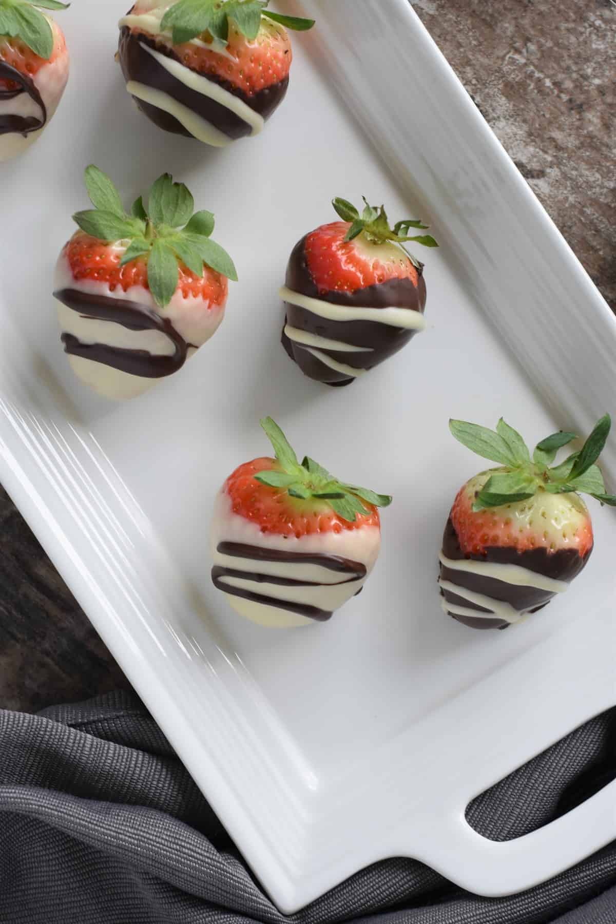 overhead of some of the dipped strawberries on white platter