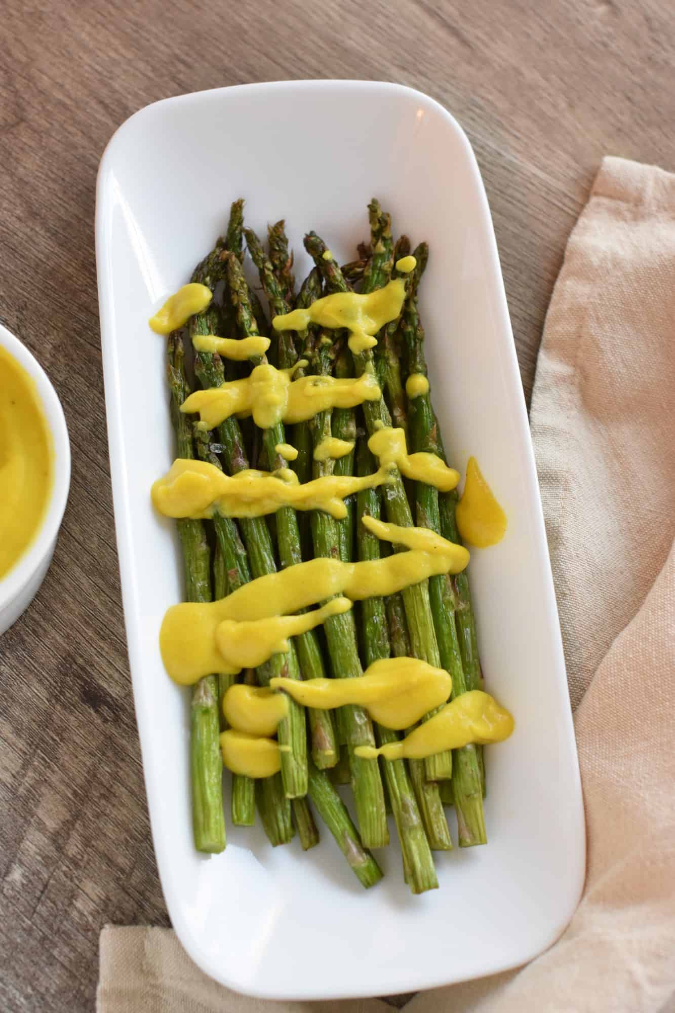 overhead of asparagus with vegan hollandaise sauce