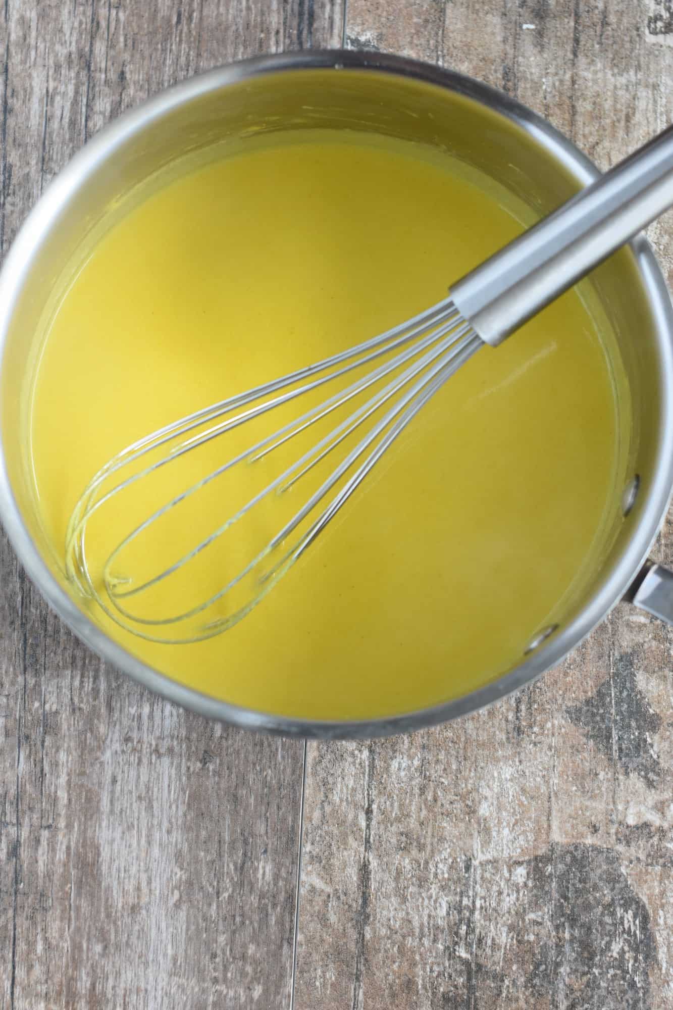 vegan hollandaise in saucepan with a whisk