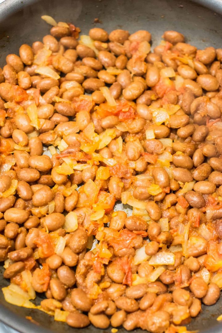 Cooked beans, onions and tomatoes in a pan