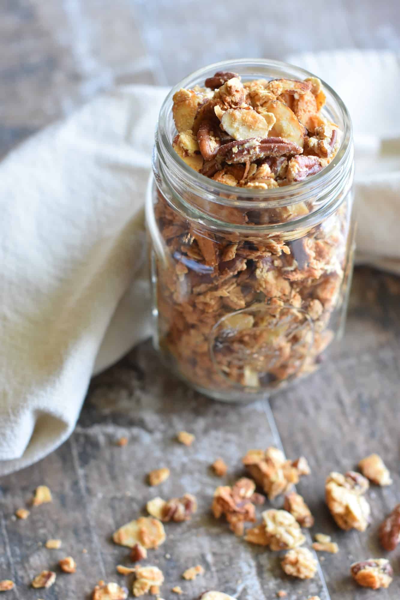 side view of granola in mason jar with some spilled on table
