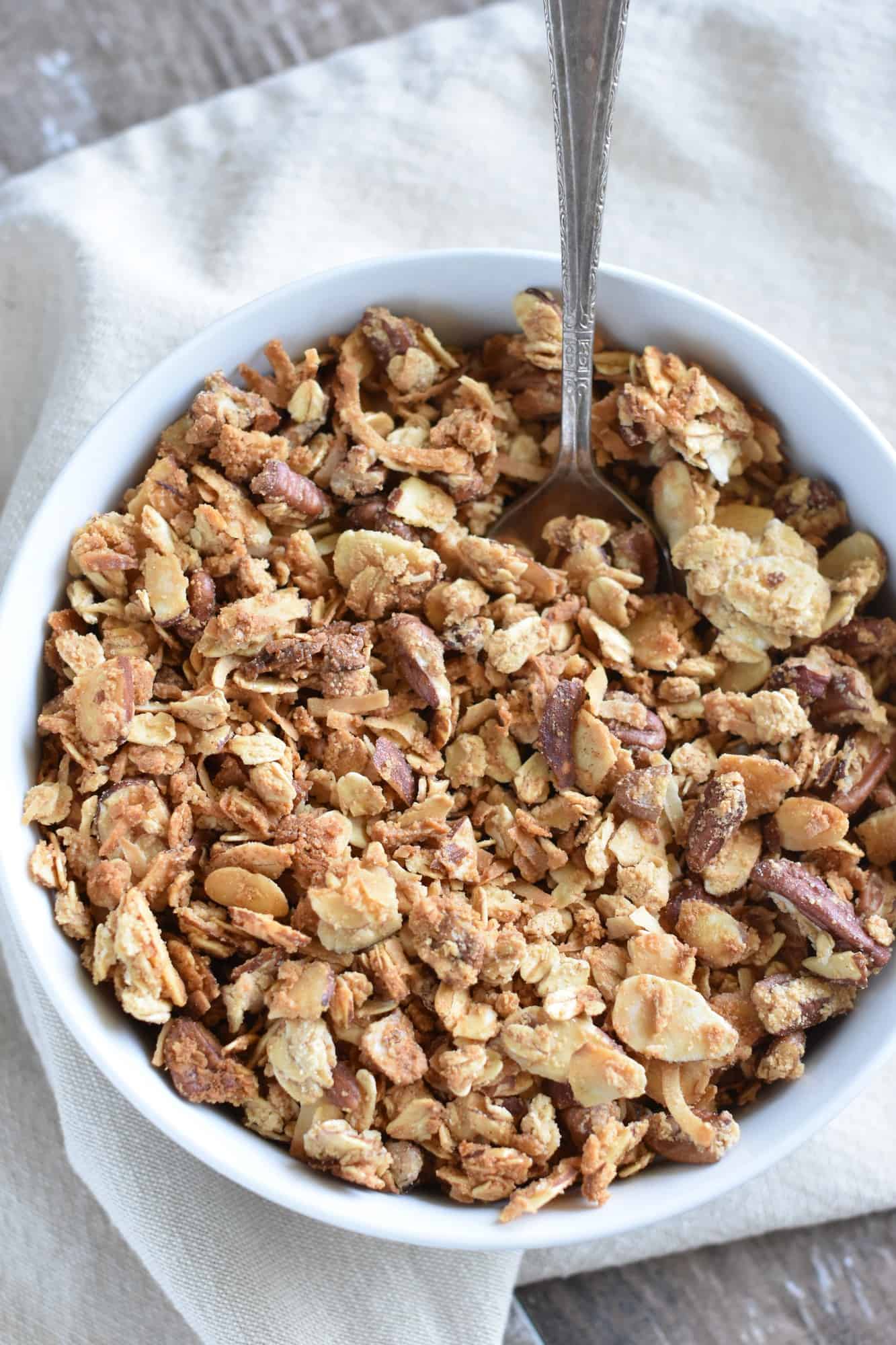 overhead of granola in a white bowl with a spoon in it