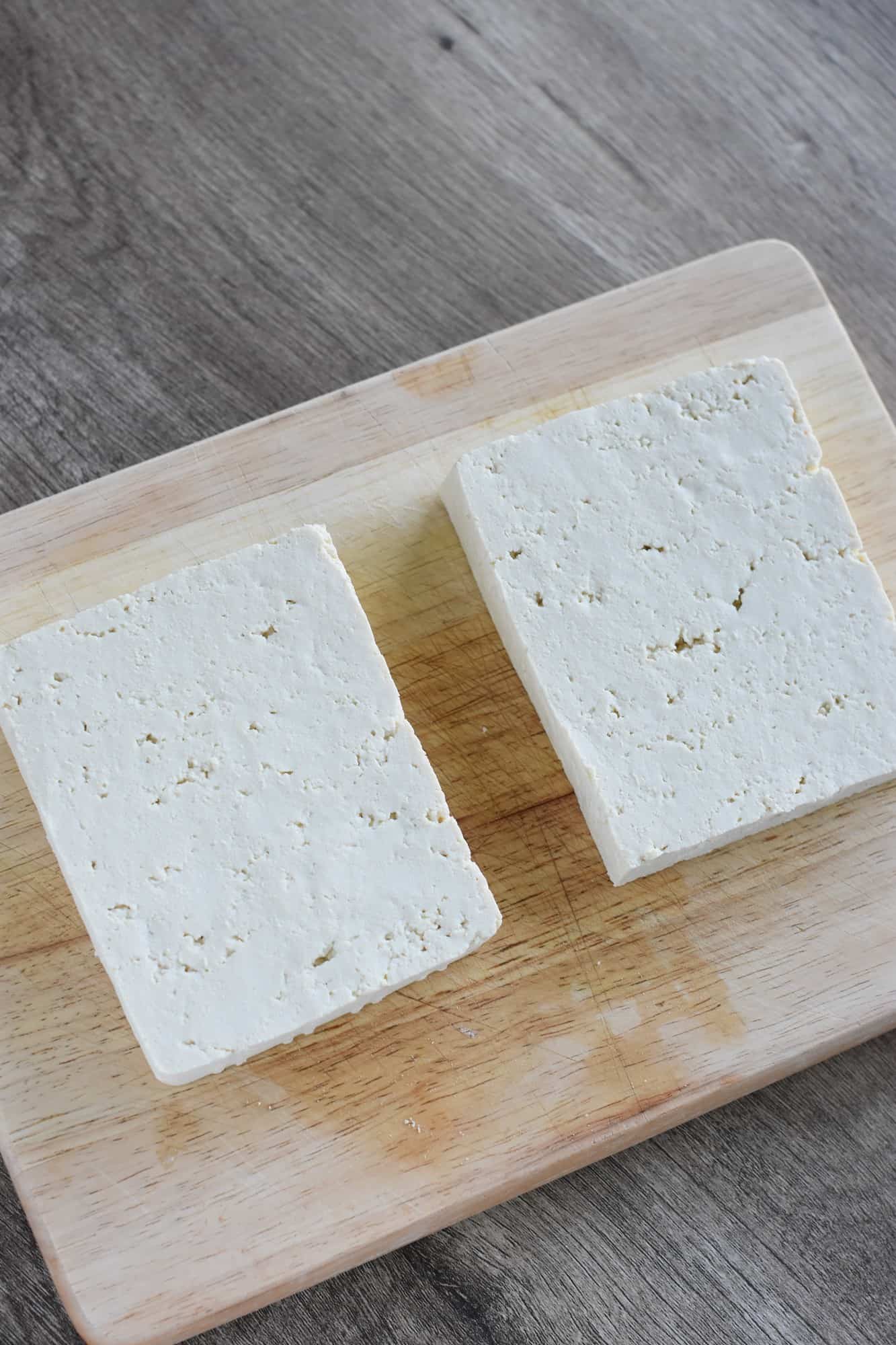 tofu sliced in half on cutting board