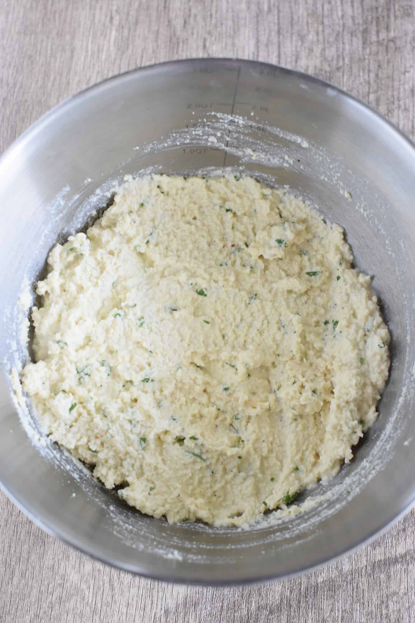 ricotta with seasoning stirred together in mixing bowl.