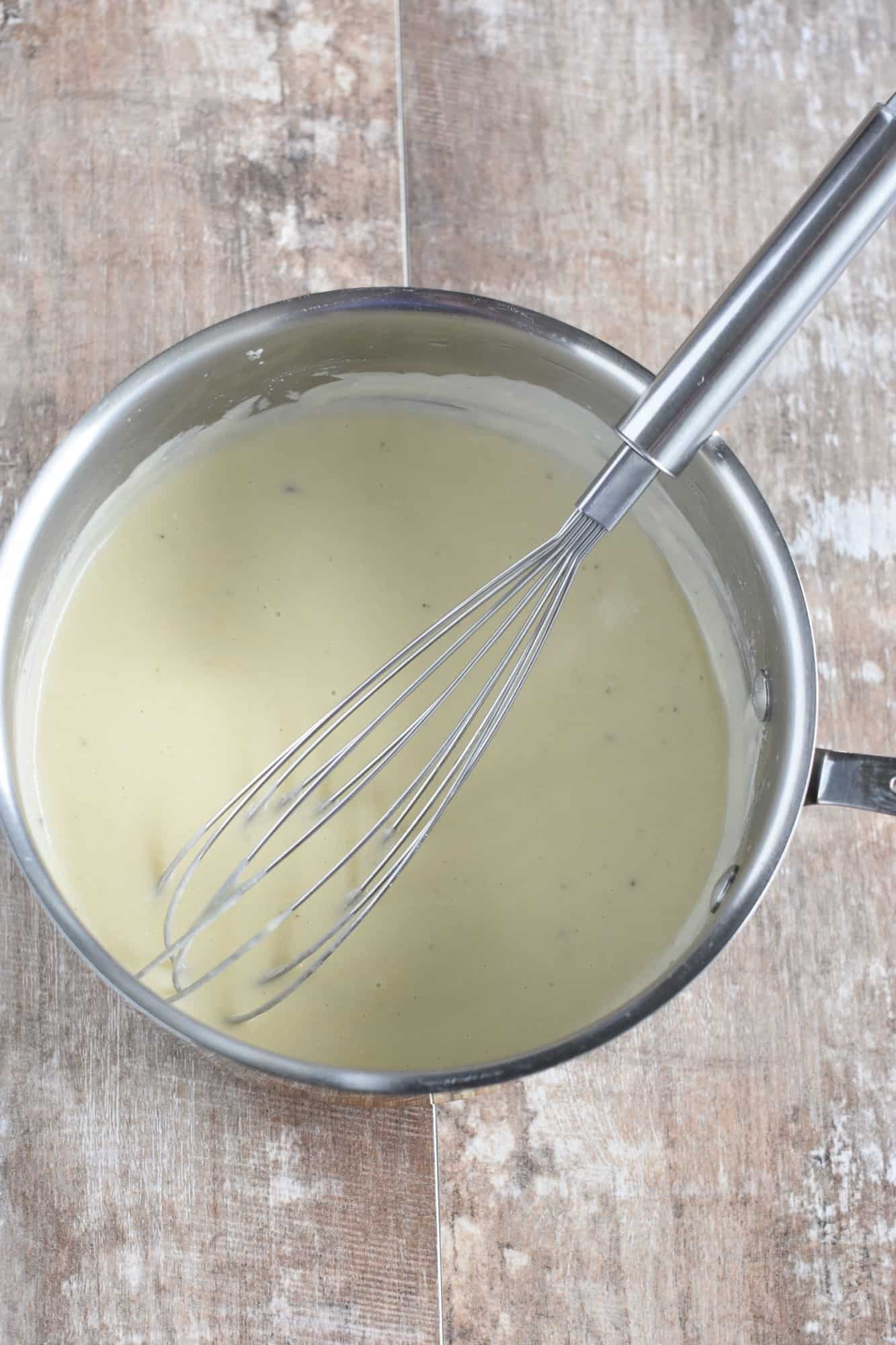 finished bechamel in saucepan with a whisk