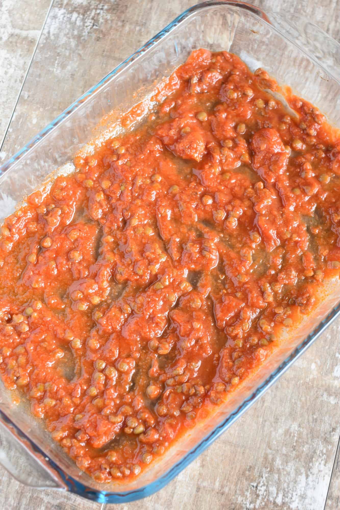 baking dish lined with lentil pasta sauce