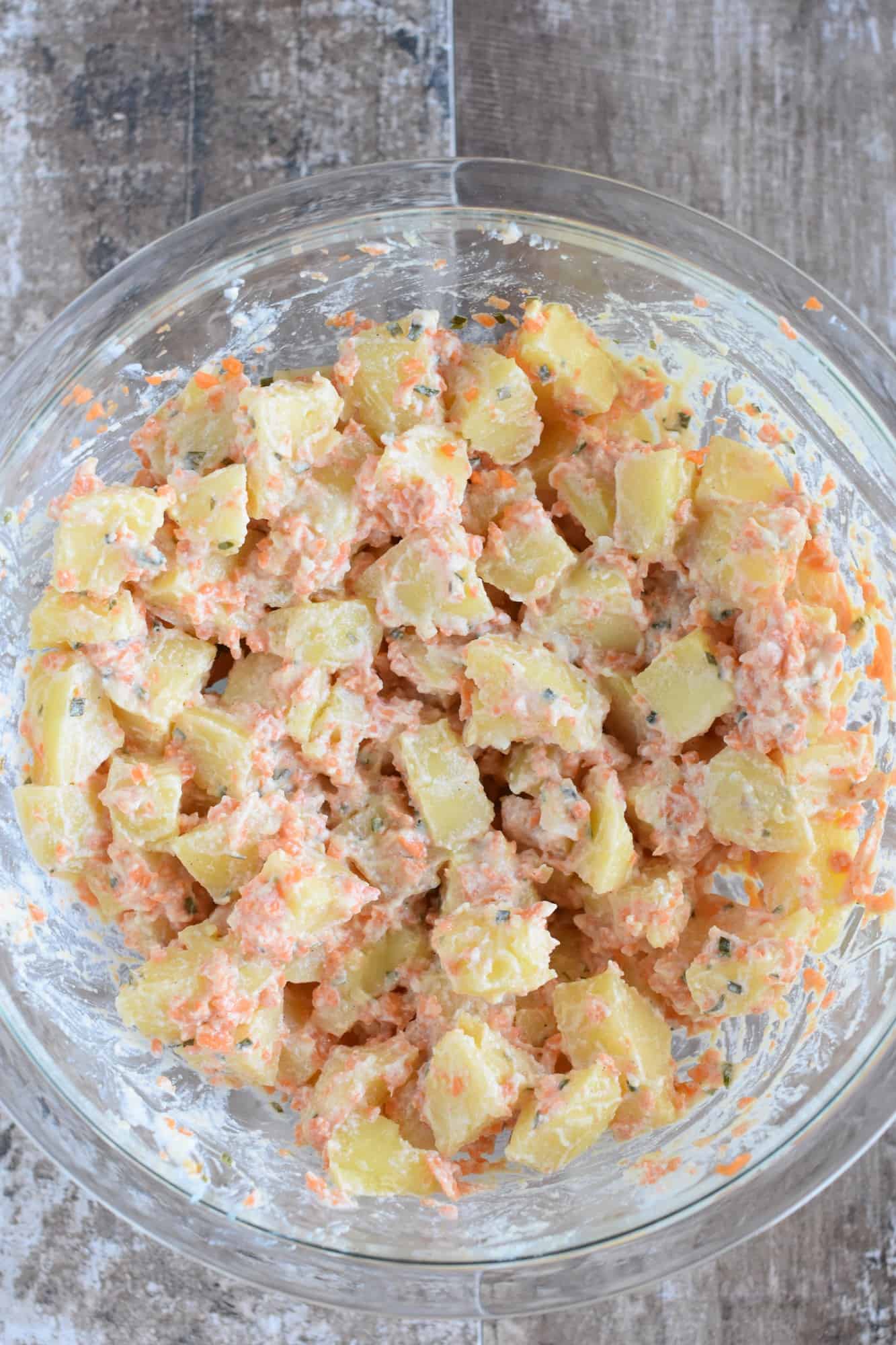 ingredients stirred into potato salad in the mixing bowl
