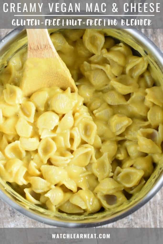 pin showing mac and cheese in a saucepan with a wooden spoon