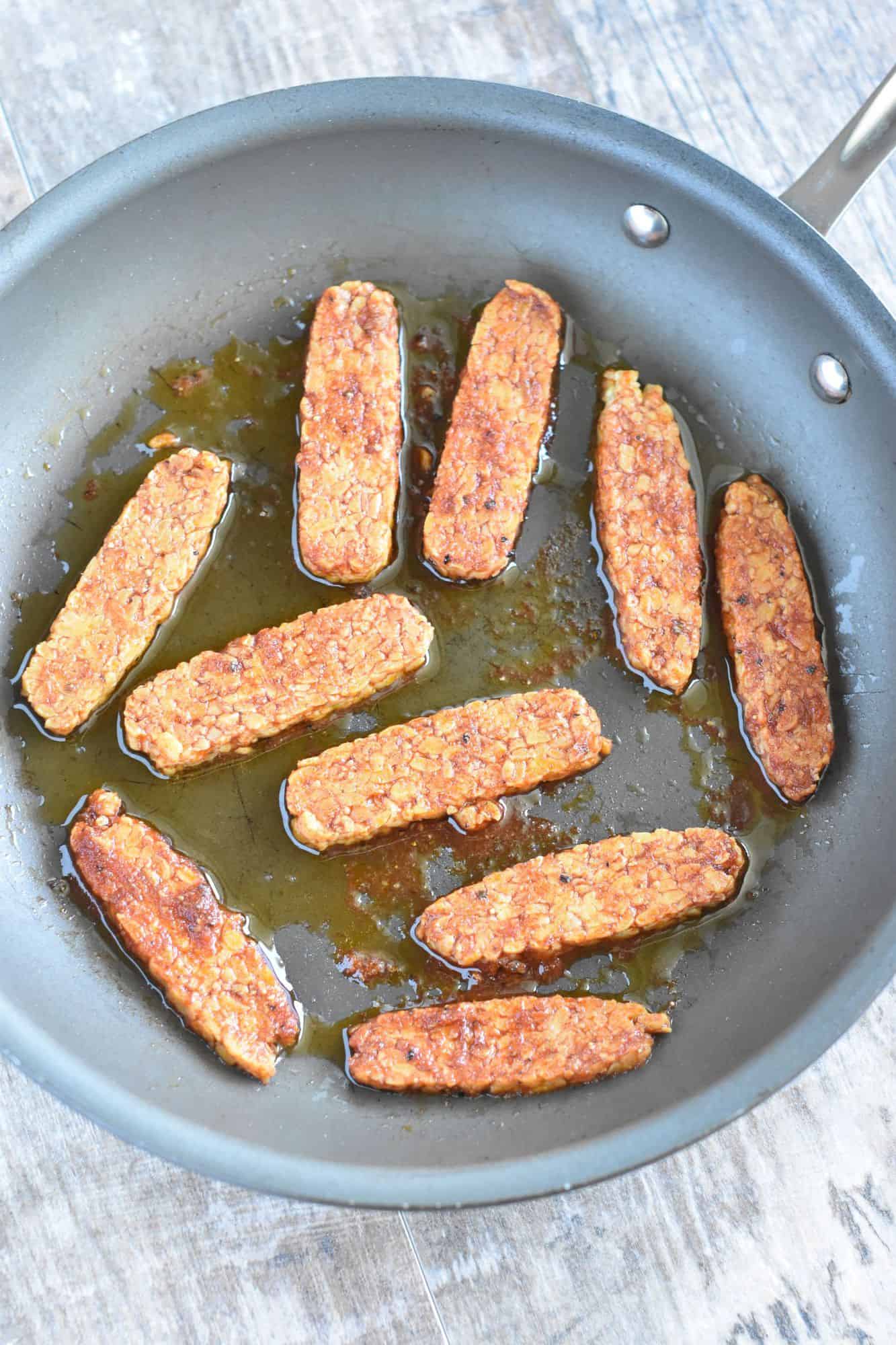tempeh strips in a nonstick pan with olive oil